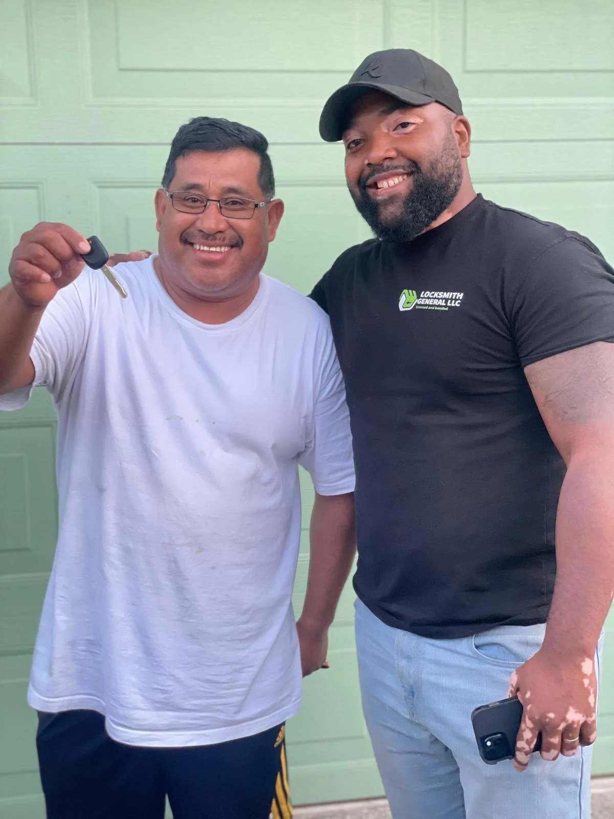 locksmith general llc technician standing next to Portland resident smiling to a picture while the client is holding a set of keys